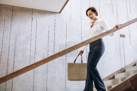 Téléchargez les photos : Femme d'affaires marchant les escaliers de l'hôtel à sa chambre - en image libre de droit