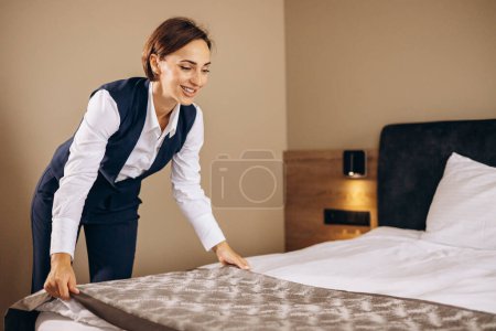 Photo for Woman housekeeper preparing bed cloths in the hotel room - Royalty Free Image