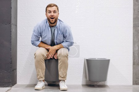 Téléchargez les photos : Homme assis sur les toilettes au marché du bâtiment - en image libre de droit