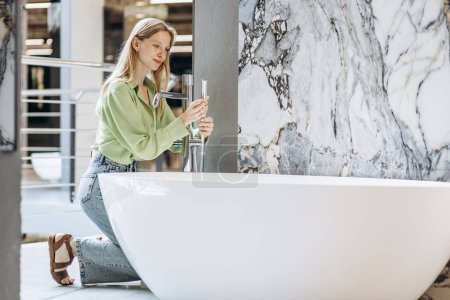 Foto de Mujer buscando baño en casa de cerámica y materiales de plomería - Imagen libre de derechos