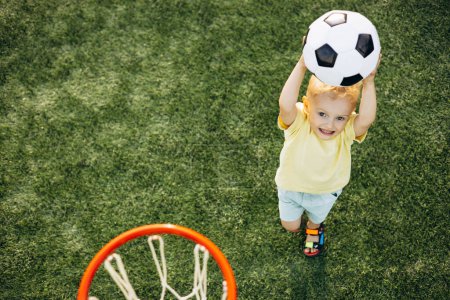 Photo for Boy learning to throw a ball into the basket - Royalty Free Image