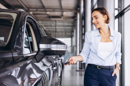 Foto de Mujer de pie junto a su nuevo coche y sosteniendo las llaves del coche - Imagen libre de derechos