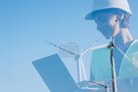 Téléchargez les photos : Femme avec ordinateur portable ayant conférence en ligne par les éoliennes - en image libre de droit