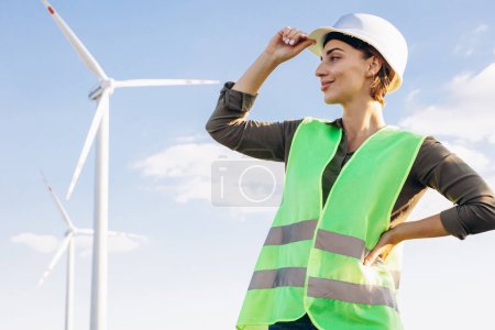 Téléchargez les photos : Portrait de femme ingénieur debout près des éoliennes - en image libre de droit