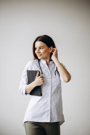 Téléchargez les photos : Jeune femme médecin en blouse de laboratoire avec stéthoscope - en image libre de droit