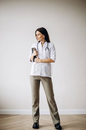 Foto de Doctora joven en bata de laboratorio con estetoscopio - Imagen libre de derechos