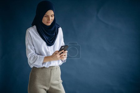 Téléchargez les photos : Femme musulmane utilisant un téléphone portable - en image libre de droit