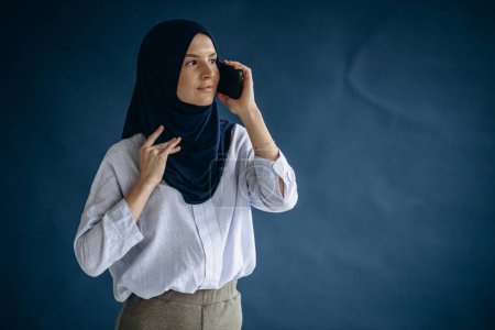 Photo for Muslim woman using mobile phone - Royalty Free Image