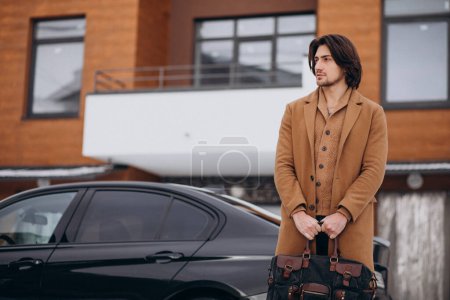 Téléchargez les photos : Jeune homme d'affaires beau qui sort de la maison pour aller à sa voiture - en image libre de droit