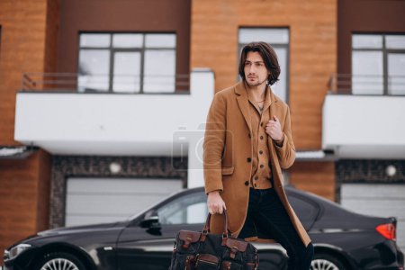 Foto de Joven hombre de negocios guapo caminando fuera de la casa a su coche - Imagen libre de derechos