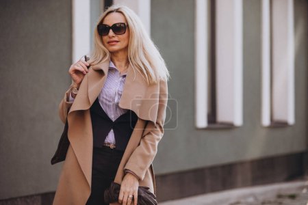 Téléchargez les photos : Femme d'affaires âgée dans un manteau à l'extérieur de la rue - en image libre de droit