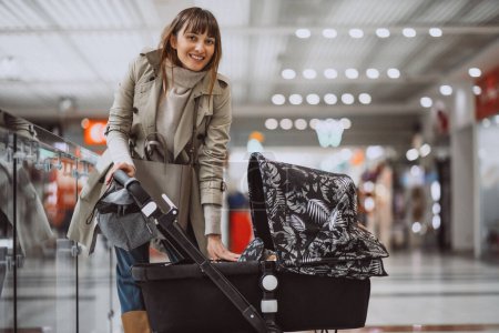 Photo for Woman with baby carriage in shopping mall - Royalty Free Image