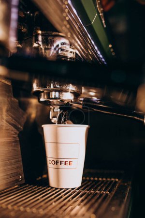 Photo for Barista making coffee in a coffee machine in a cardboard - Royalty Free Image