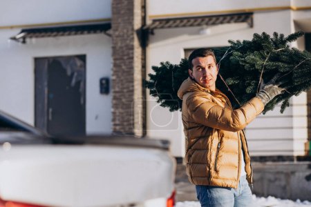 Photo for Father carrying christmas tree home - Royalty Free Image