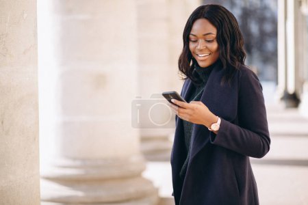 Photo for African american student girl with phone by the university - Royalty Free Image