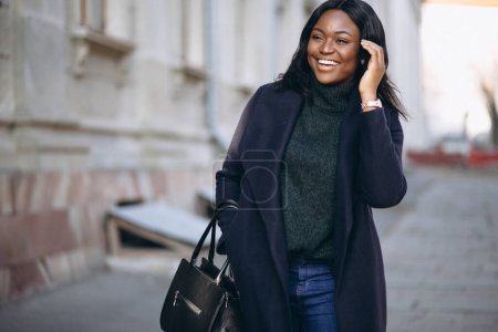 Téléchargez les photos : Femme afro-américaine modèle en manteau dans la rue - en image libre de droit