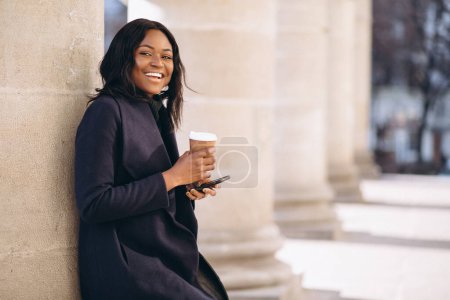 Photo for African american woman with phone drinking coffee - Royalty Free Image