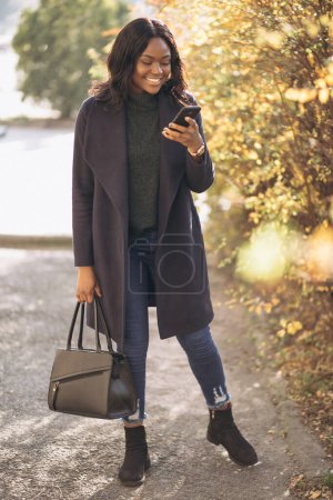 Photo for African american woman with phone in park - Royalty Free Image