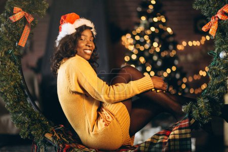 Photo for African american woman sitting by the christmas tree - Royalty Free Image
