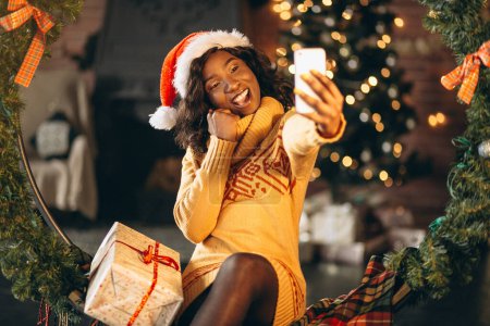 Téléchargez les photos : Femme afro-américaine parlant au téléphone à Noël - en image libre de droit