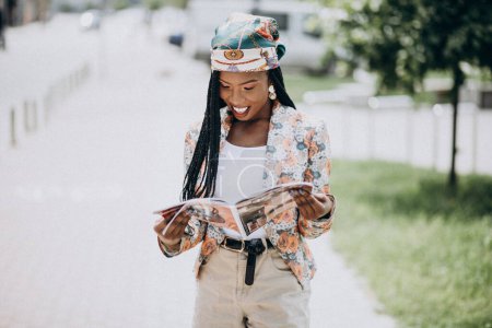Téléchargez les photos : Élégant magazine de lecture afro-américain dans la rue - en image libre de droit