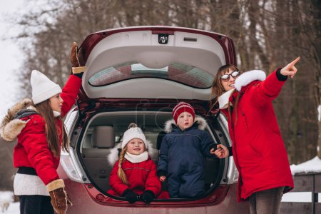 Photo for Family sitting in the back of the car outside in winter - Royalty Free Image