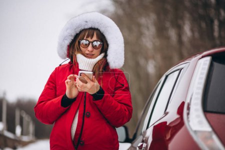 Photo for Woman happy talking on the phone outside by car in winter - Royalty Free Image