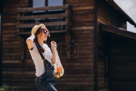 Photo for Woman with eco bag with fruit in a country side - Royalty Free Image