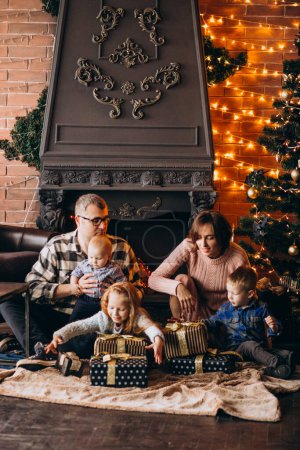 Photo for Big family on Christmas eve with presents by Christmas tree - Royalty Free Image