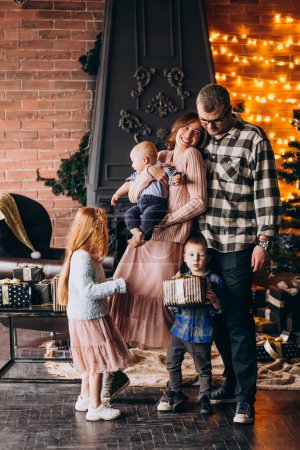 Téléchargez les photos : Grande famille la veille de Noël avec des cadeaux par arbre de Noël - en image libre de droit