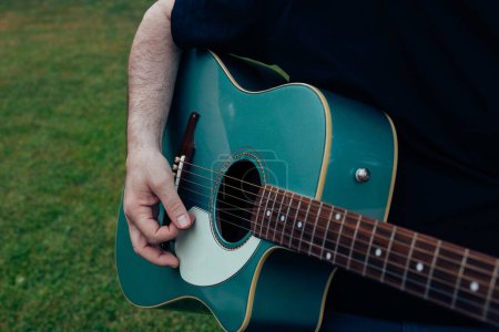 Photo for Close up of man's hand playing acoustic guitar. Musical instrument for recreation or hobby passion concept - Royalty Free Image