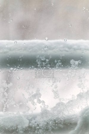 Photo for Close-up of window view of snow, frost and water accumulation during a snowfall. Selective focus - Royalty Free Image