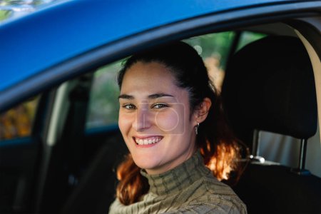 Photo for Beautiful 30 years old woman happy and smiling inside her blue car looking at camera. Concept of lifestyle and female driver - Royalty Free Image