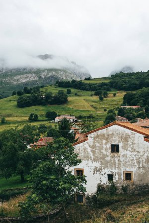 Photo for Vertical nature landscape of rural village with houses, fog on mountain and cloudy day. Concept of nature and rural lifestyle - Royalty Free Image
