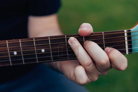 Photo for Close up of man's hand playing acoustic guitar. Musical instrument for recreation or hobby passion concept - Royalty Free Image