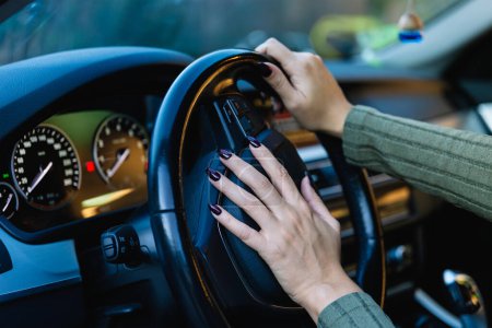 Téléchargez les photos : Main de femme klaxonnant le klaxon de sa voiture en appuyant sur le volant. Concept de conduite et de sécurité routière - en image libre de droit