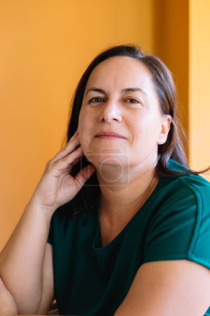Photo for Portrait 50 years old woman with loose brown hair, smiling calm and relaxed looking at the camera. Concept of mental health and middle age - Royalty Free Image