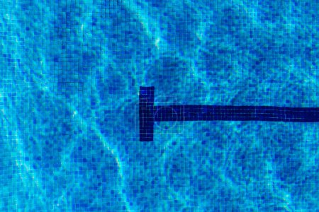 Photo for View from above of a pool full of water in summer with sunlight. Blue tiles and reflections. Concept of backgrounds and summer - Royalty Free Image