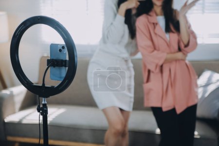 Asiatique jeune femme avec son ami tiktoker a créé sa vidéo de danse par caméra smartphone ensemble. Pour partager des vidéos sur l'application de médias sociaux