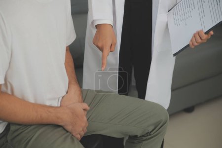 Male diseases. Man presses hands to his groin and suffering from pain, panorama, cropped, studio shot