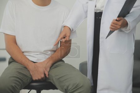 Male diseases. Man presses hands to his groin and suffering from pain, panorama, cropped, studio shot