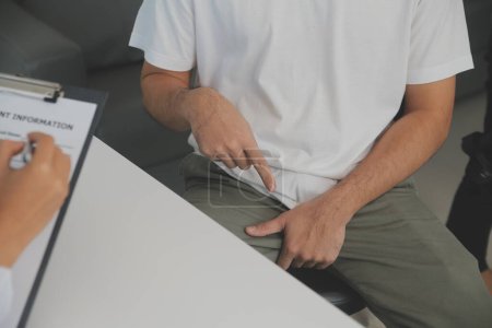 Männerkrankheiten. Mann drückt Hände an die Leiste und leidet unter Schmerzen, Panorama, Schnitt, Studioaufnahme