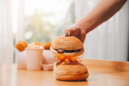 Binge-Eating-Störungskonzept: Frau isst Fast-Food-Burger, gebranntes Huhn, Donuts und Desserts