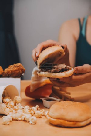Fast Food, Menschen und ungesundes Ernährungskonzept - Nahaufnahme von Frauenhänden, die Hamburger oder Cheeseburger halten