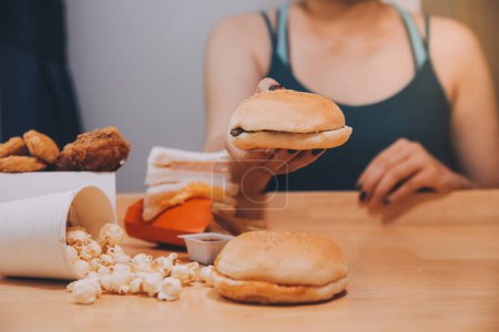 fast food, personnes et concept de mauvaise alimentation - gros plan des mains de la femme tenant un hamburger ou un cheeseburger
