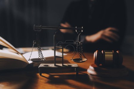 Gesetzesbücher und Justizwaagen auf dem Schreibtisch in der Bibliothek der Anwaltskanzlei. Rechtswissenschaft Rechtsbildungskonzept.