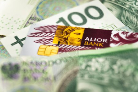 Foto de Wabrzych, poland - 11.12.2023: logotipo del banco Alior en una tarjeta de crédito entre los billetes zloty polacos. Alior Bank es uno de los mayores bancos de Polonia financiados en 2008 - Imagen libre de derechos