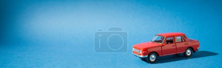 Foto de Coche de juguete rojo aislado sobre fondo azul - Imagen libre de derechos