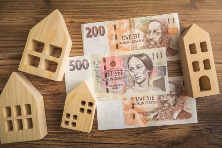 Casas de madera y billetes de la corona checa en una mesa de madera economía doméstica y la inflación en Chequia
