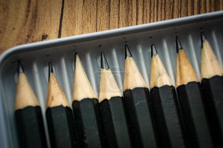 Reihe schwarzer Bleistifte im Metallbehälter